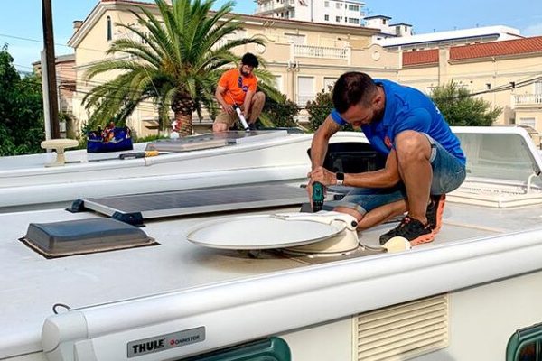 Técnicos de Caravaning Benicarló instalando paneles solares para sistema de litio en el techo de una autocaravana